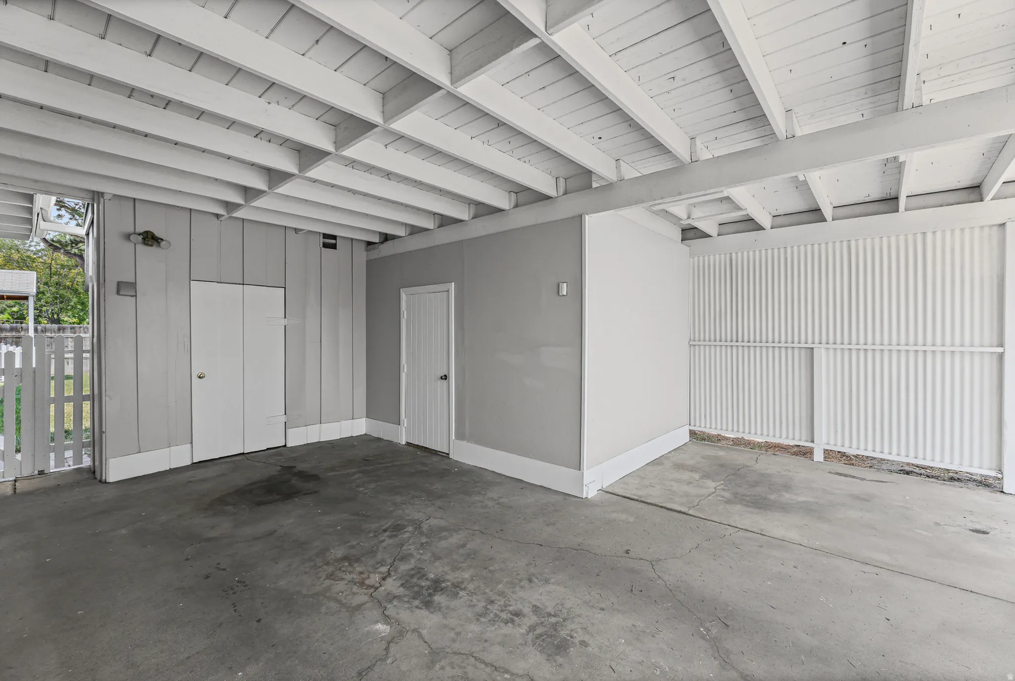 Covered concrete-pad carport featuring storage.