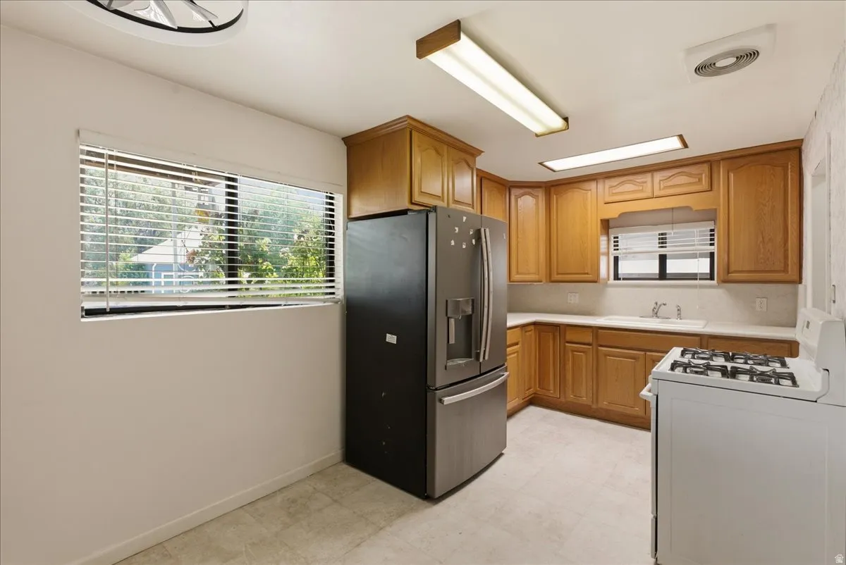 Kitchen featuring wood cabinetry, solid surface countertops, and white tile flooring