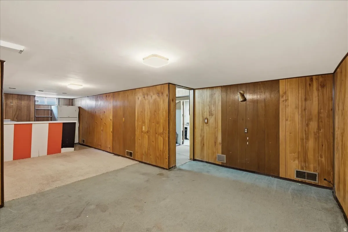 Lower level featuring wood paneling, recessed lighting, and mixed flooring