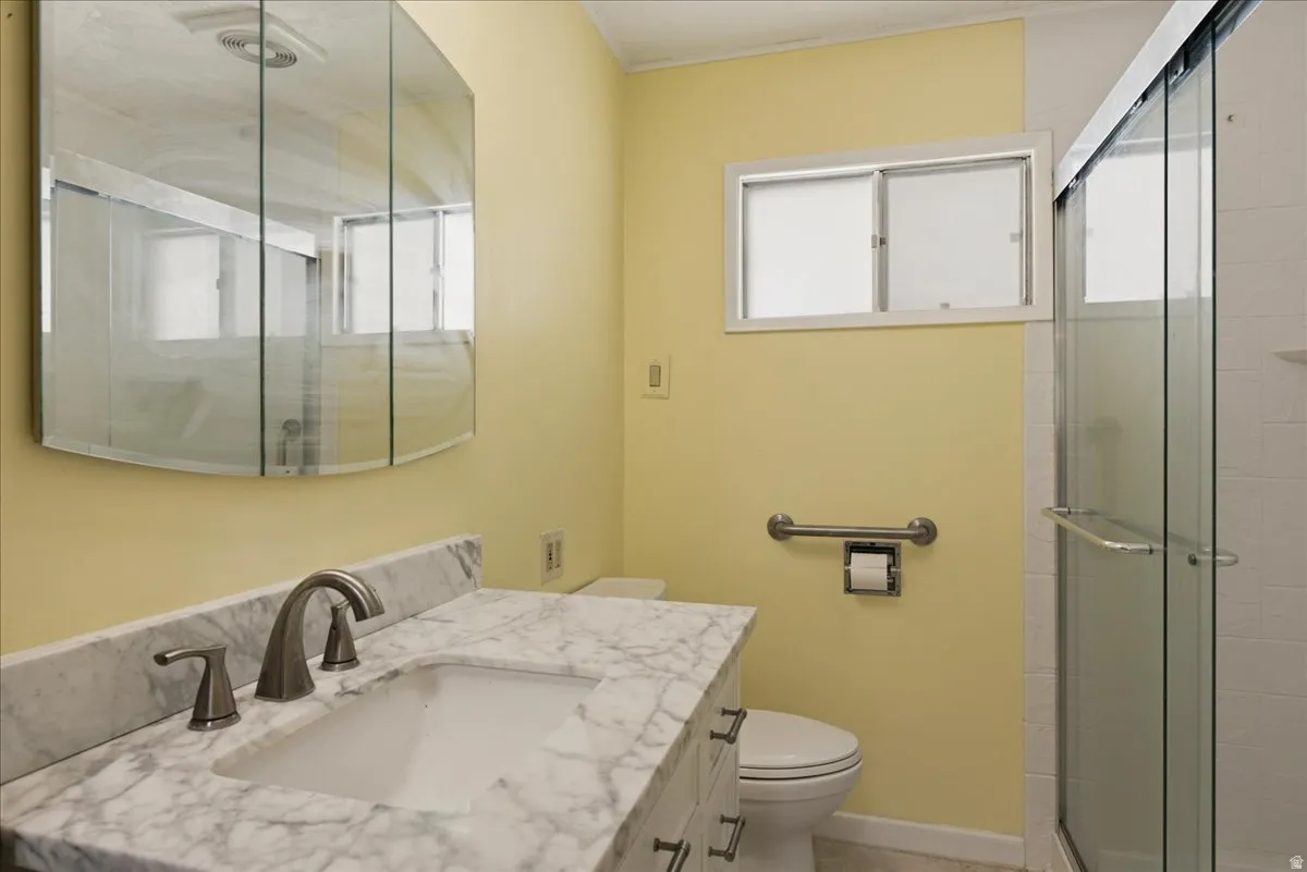 Bathroom featuring a white marble-patterned vanity countertop with an integrated sink and brushed nickel faucet