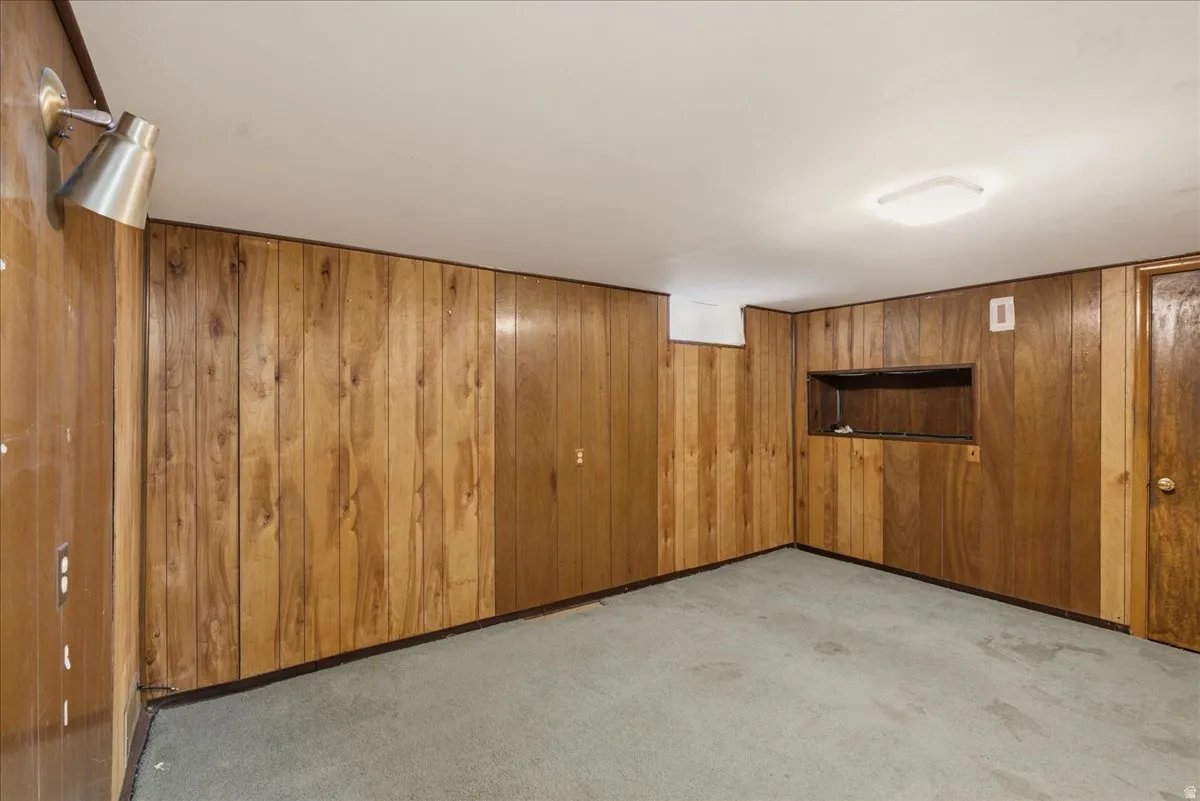 Wood paneling throughout the room, featuring a built-in recessed shelf and a flush-mount ceiling light fixture
