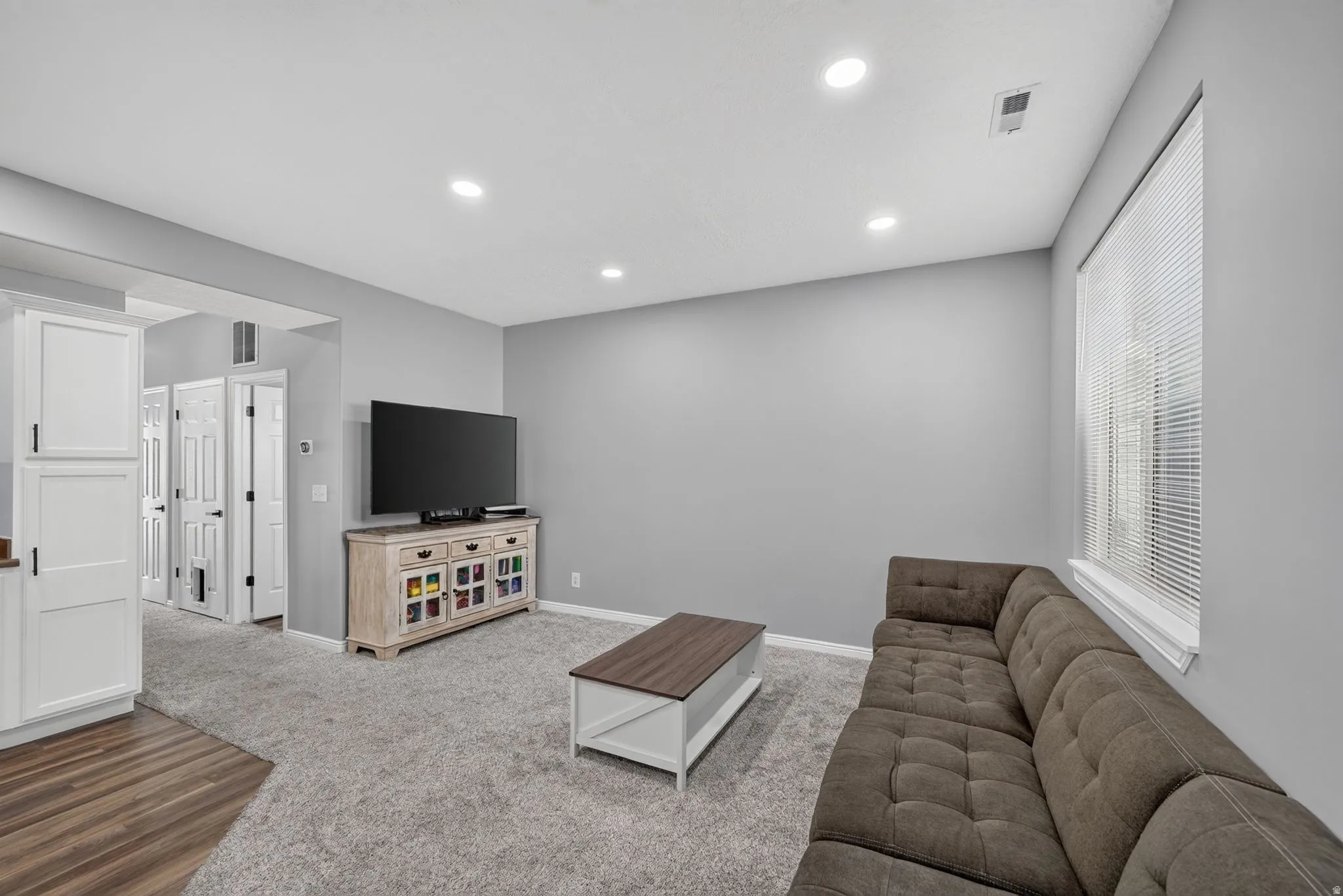 Living area featuring a textured gray carpet and light gray wall paint