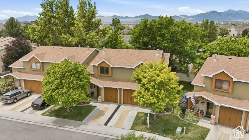 Contemporary residential building featuring a two-car garage, earth-toned stucco exterior, and gable roofline with dormers