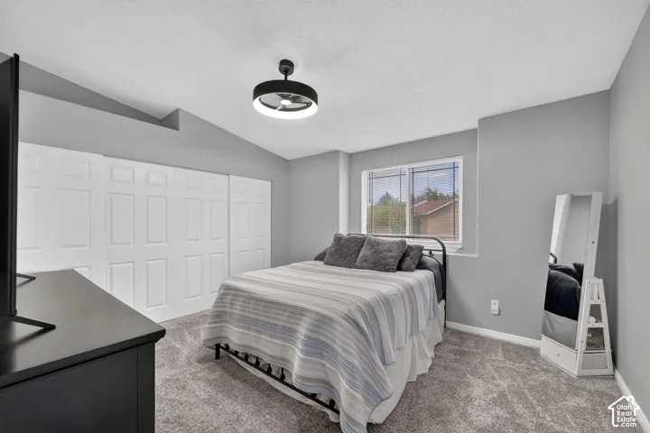 Carpeted interior space featuring light gray walls, white baseboards, and a contemporary ceiling light fixture