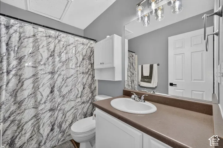 Bathroom featuring a single vanity with an integrated sink, broad countertop, and under-sink cabinetry