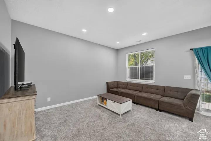Spacious room featuring neutral grey walls and recessed lighting