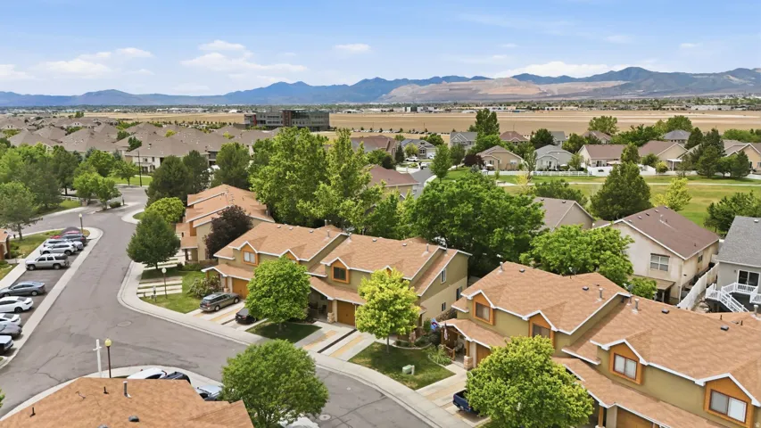 Residential community featuring townhomes with light brown siding and brown shingle roofs