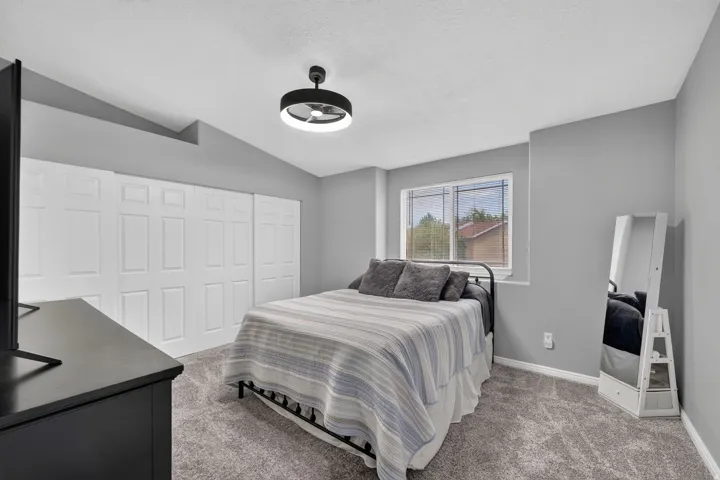 Carpeted interior space featuring light gray walls, white baseboards, and a contemporary ceiling light fixture