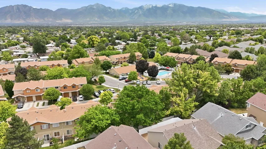 Aerial view of a residential community featuring townhomes with light brown siding and tan shingle roofs