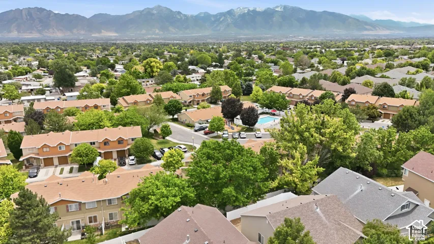 Aerial view of a residential community featuring townhomes with light brown siding and tan shingle roofs