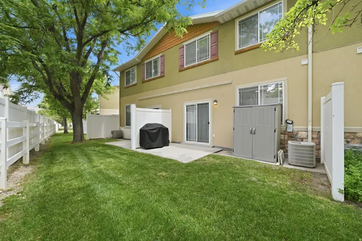 Expansive green space featuring mature trees and a white picket fence