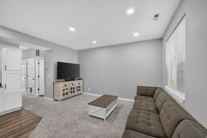 Living area featuring a textured gray carpet and light gray wall paint