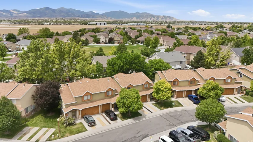 Residential street featuring townhomes with attached garages and driveways