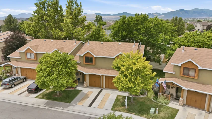 Contemporary residential building featuring a two-car garage, earth-toned stucco exterior, and gable roofline with dormers