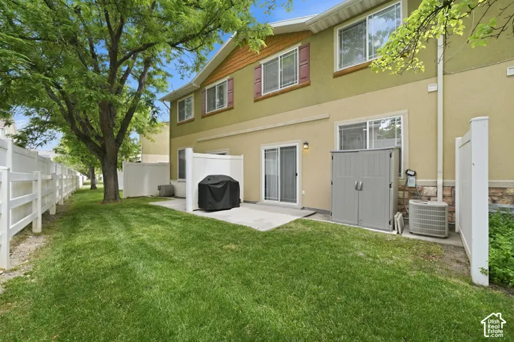 Expansive green space featuring mature trees and a white picket fence