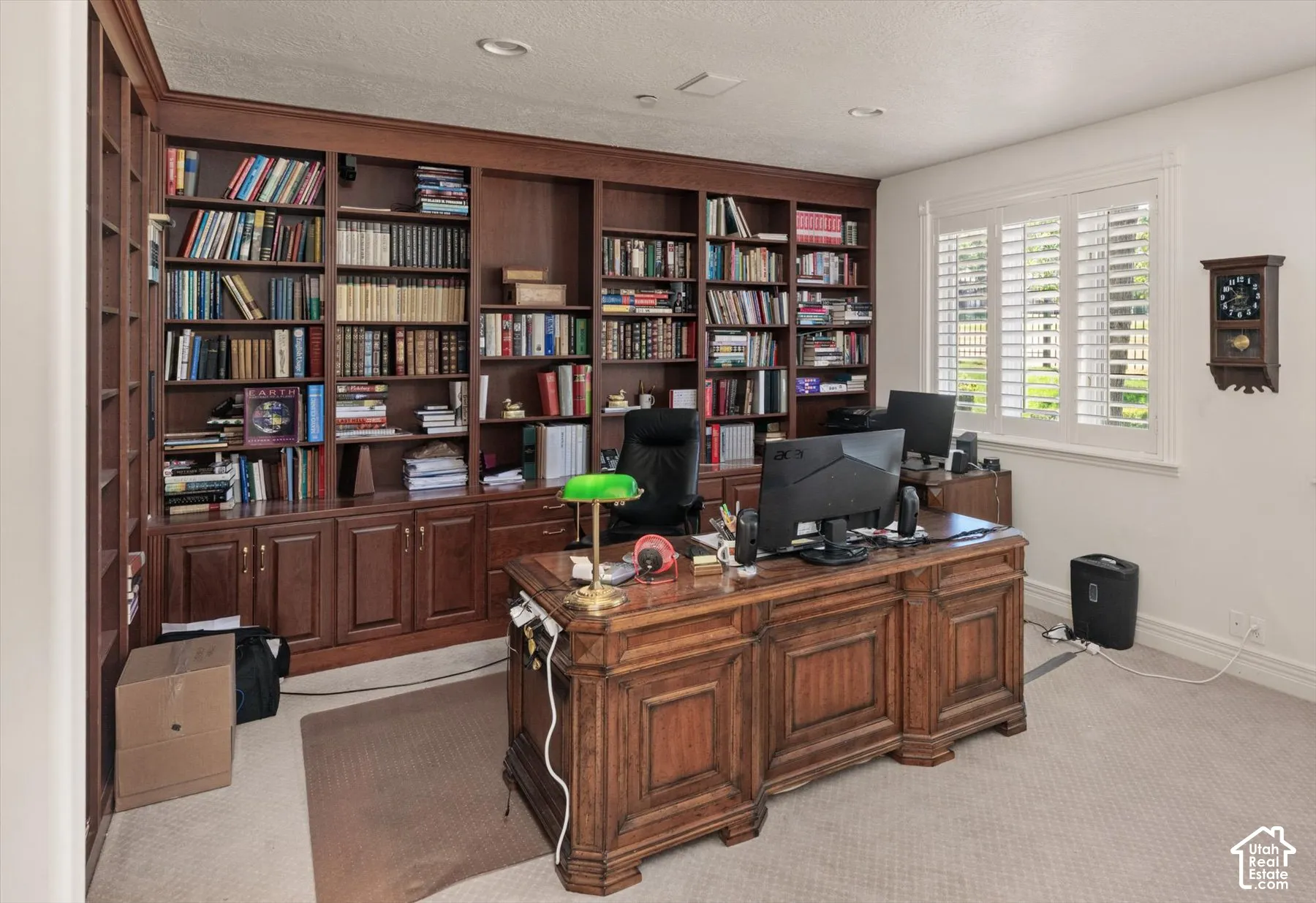 Dedicated office space featuring extensive built-in wood cabinetry and shelving, or bedroom