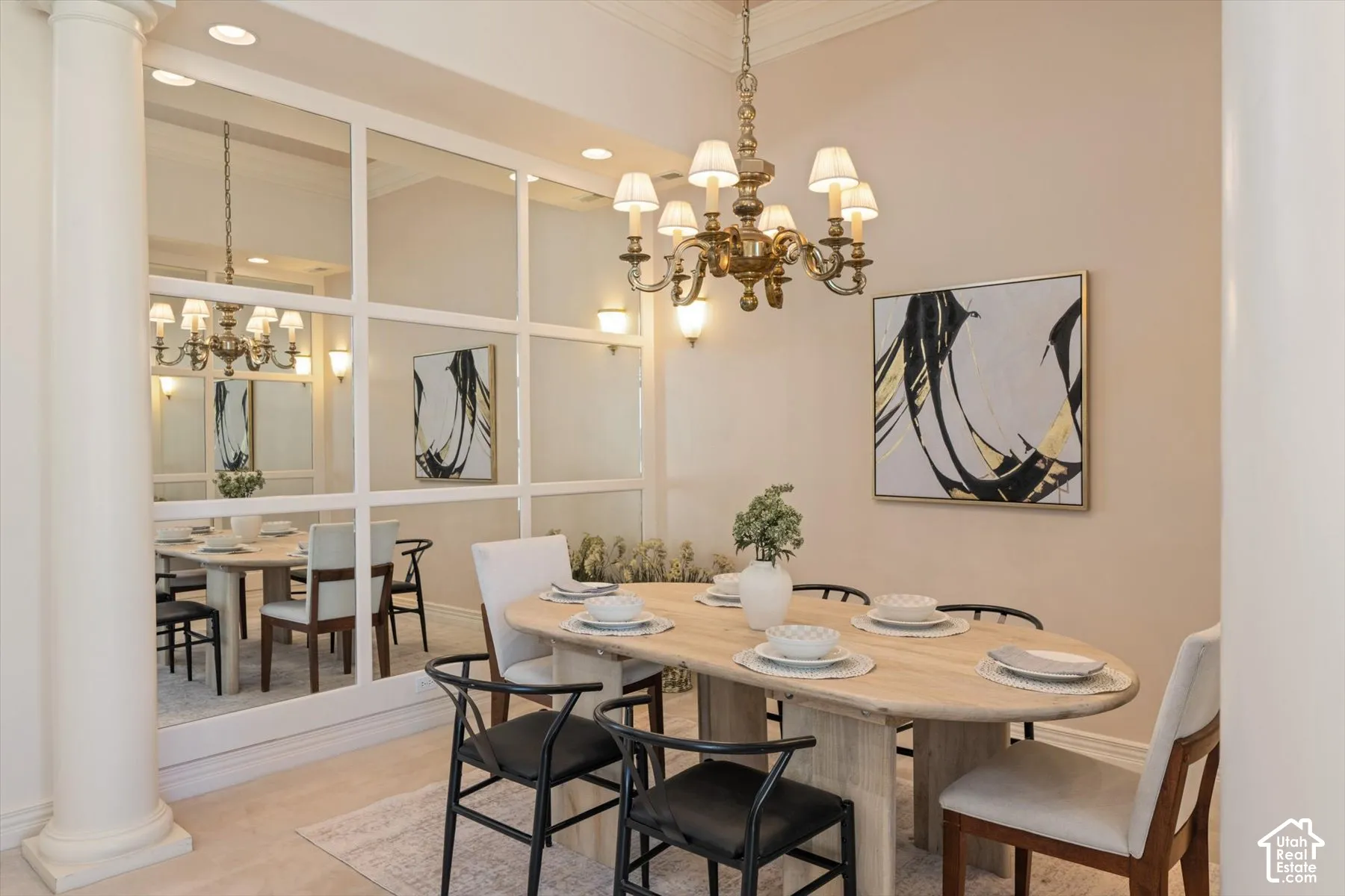 Formal dining area featuring a prominent mirrored wall, a classic brass chandelier, and a decorative wall sconce