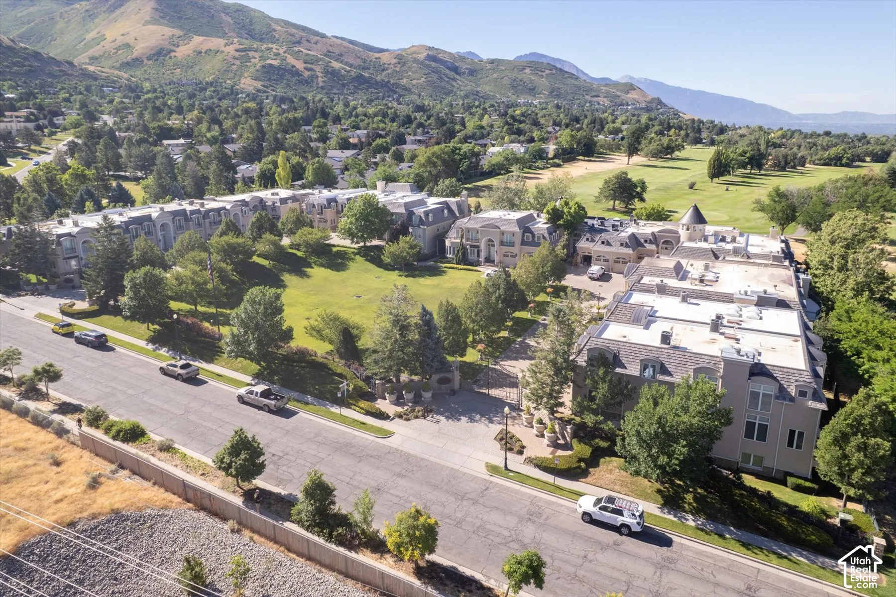 Aerial view showcasing multiple residential buildings, a manicured green space, and a golf course