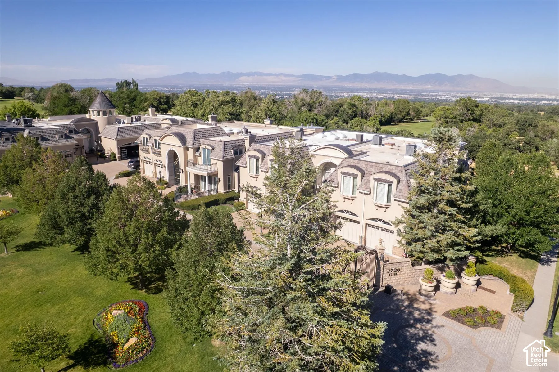 Expansive estate featuring a grand architectural design, multiple garage bays, and a turret structure
