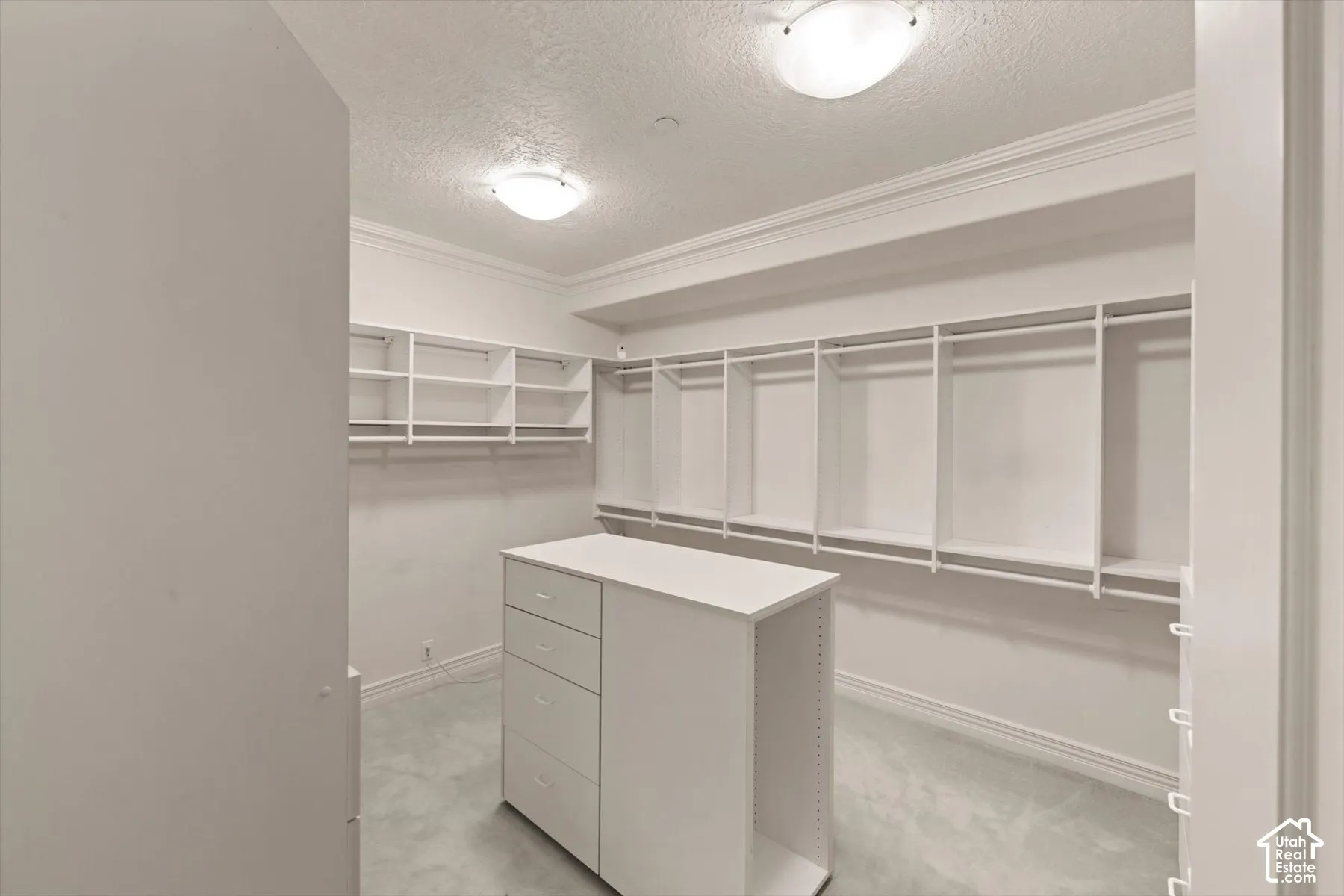Customizable closet system with a central dresser island featuring multiple drawers and open shelving