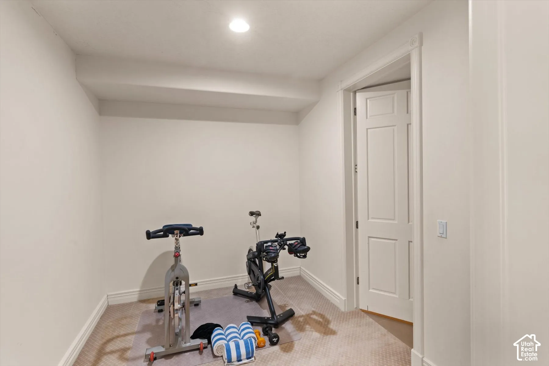 Carpeted room with recessed lighting and a single panel interior door