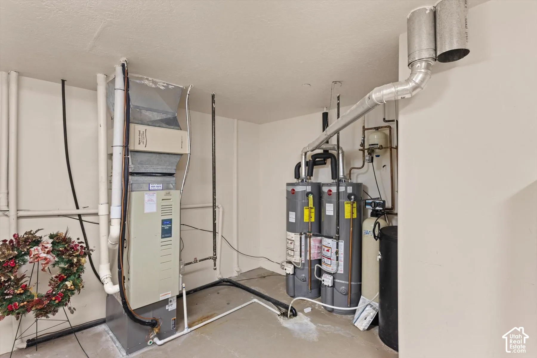Utility area featuring a forced air furnace, two water heaters, and a water softener system