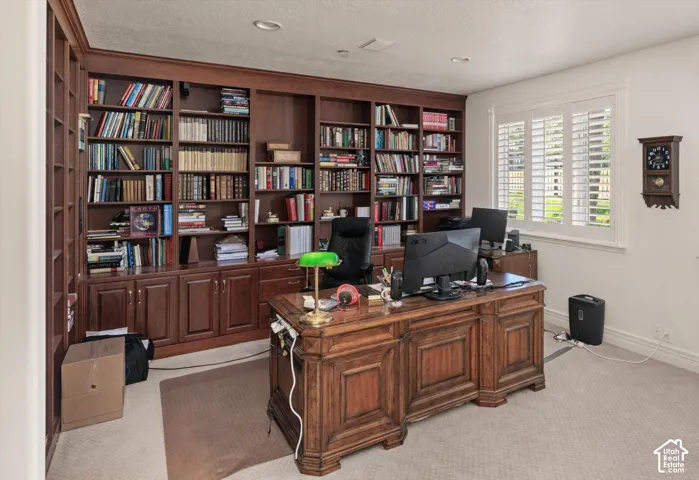 Dedicated office space featuring extensive built-in wood cabinetry and shelving, or bedroom