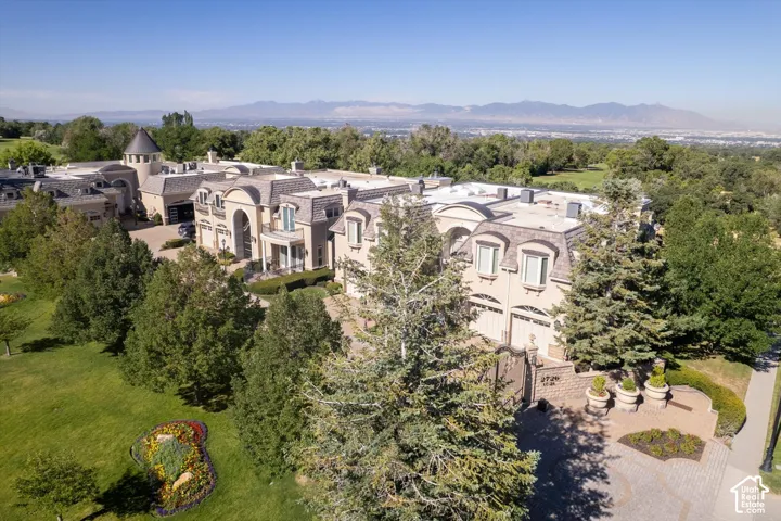 Expansive estate featuring a grand architectural design, multiple garage bays, and a turret structure