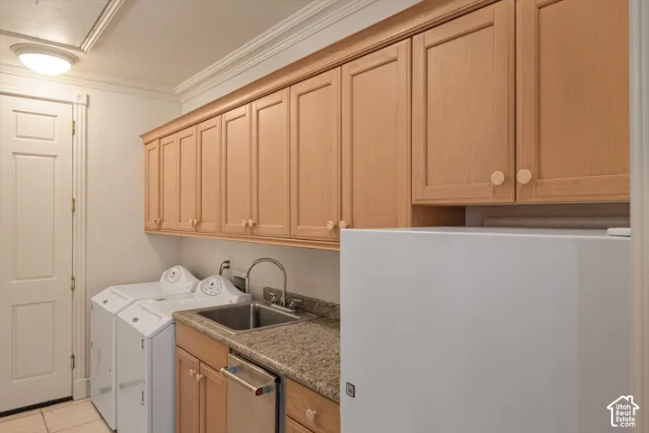 Laundry area with overhead wood cabinetry, granite countertop, and stainless-steel sink with a high-arc faucet, and extra refrigerator off kitchen