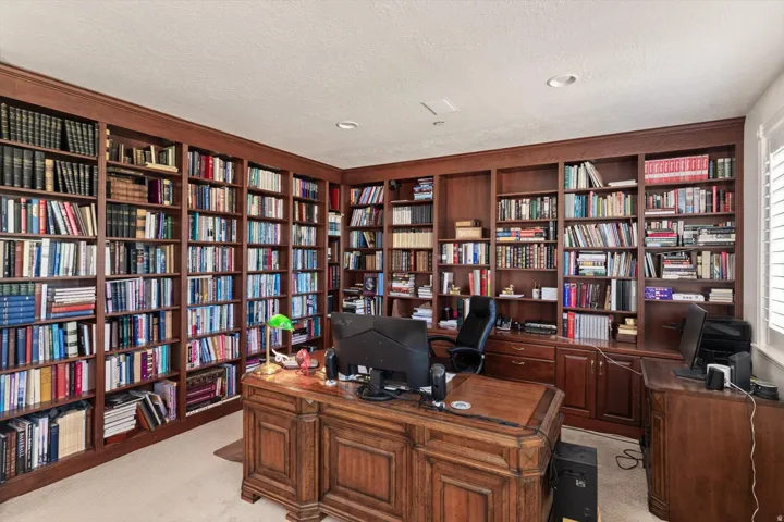 Extensive built-in wood cabinetry lines the walls, offering comprehensive storage and display capabilities, could also be bedroom
