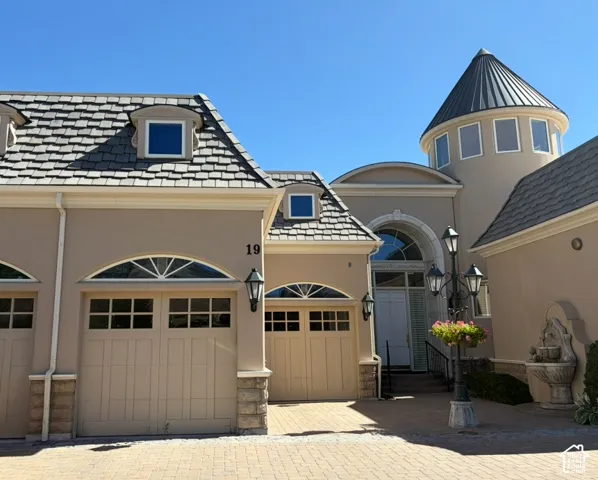 Stucco exterior featuring a prominent turret with a conical roof and multiple windows
