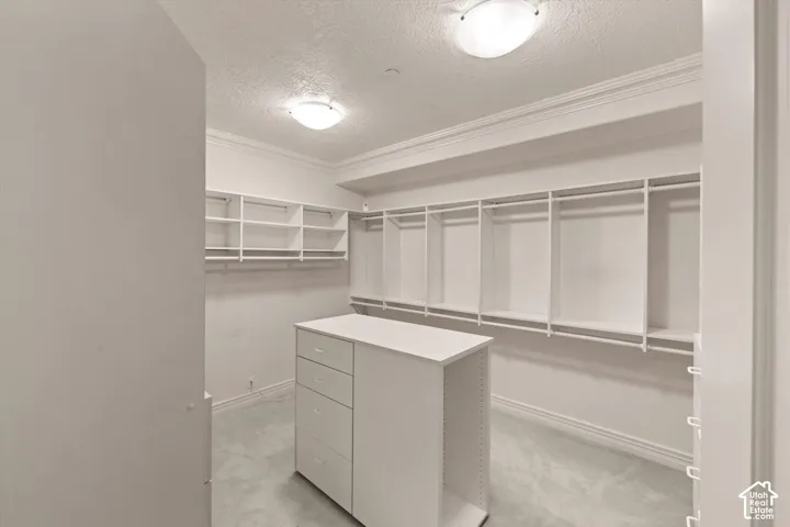 Customizable closet system with a central dresser island featuring multiple drawers and open shelving