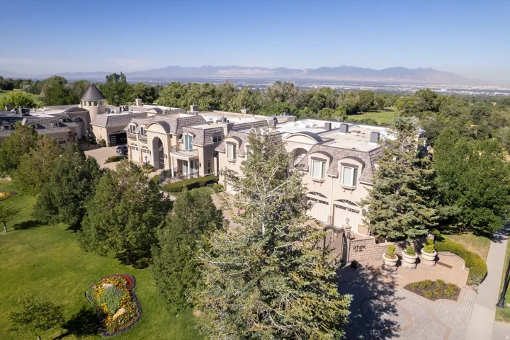 Expansive estate featuring a grand architectural design, multiple garage bays, and a turret structure