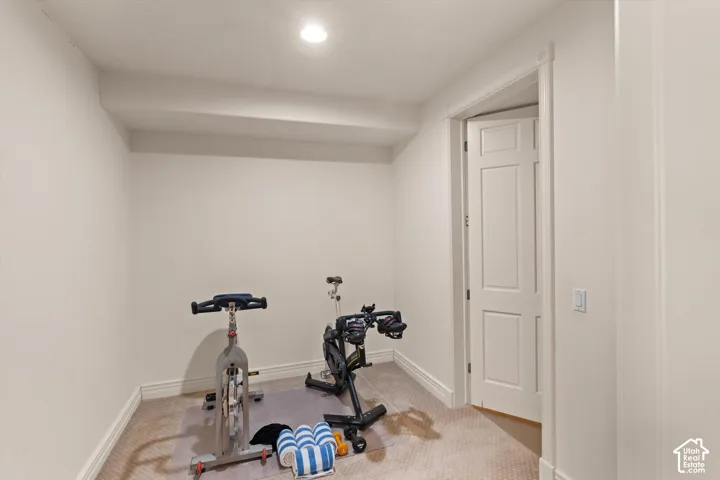 Carpeted room with recessed lighting and a single panel interior door