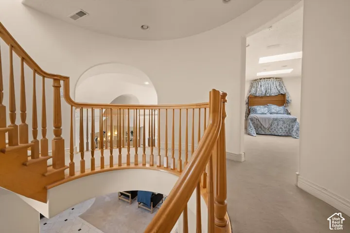 Curved natural wood staircase with balusters and handrail