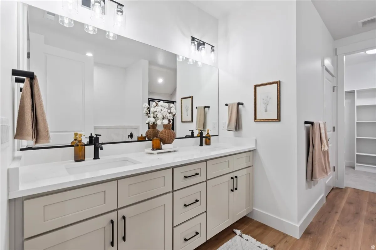 Dual vanity with light-toned shaker cabinetry and matte black hardware