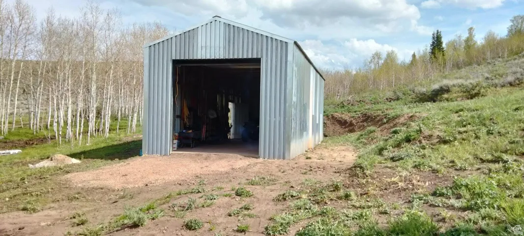 Corrugated metal outbuilding featuring a wide entry door