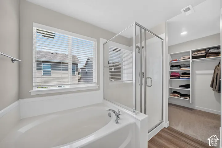 Soaking tub with chrome fixtures and an adjacent glass-enclosed shower