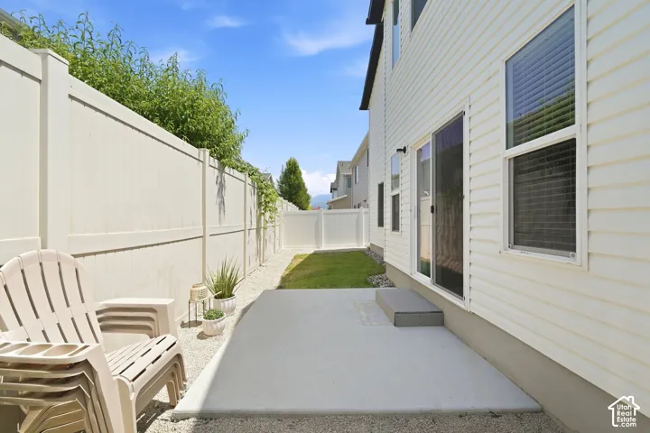 Private outdoor space featuring a concrete patio, gravel border, and a strip of green lawn