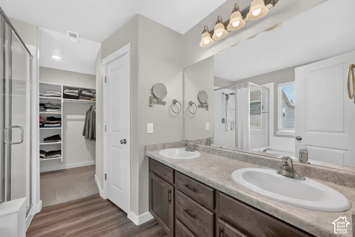 Spacious bathroom featuring a dual vanity with wood-finish cabinetry and a large mirror
