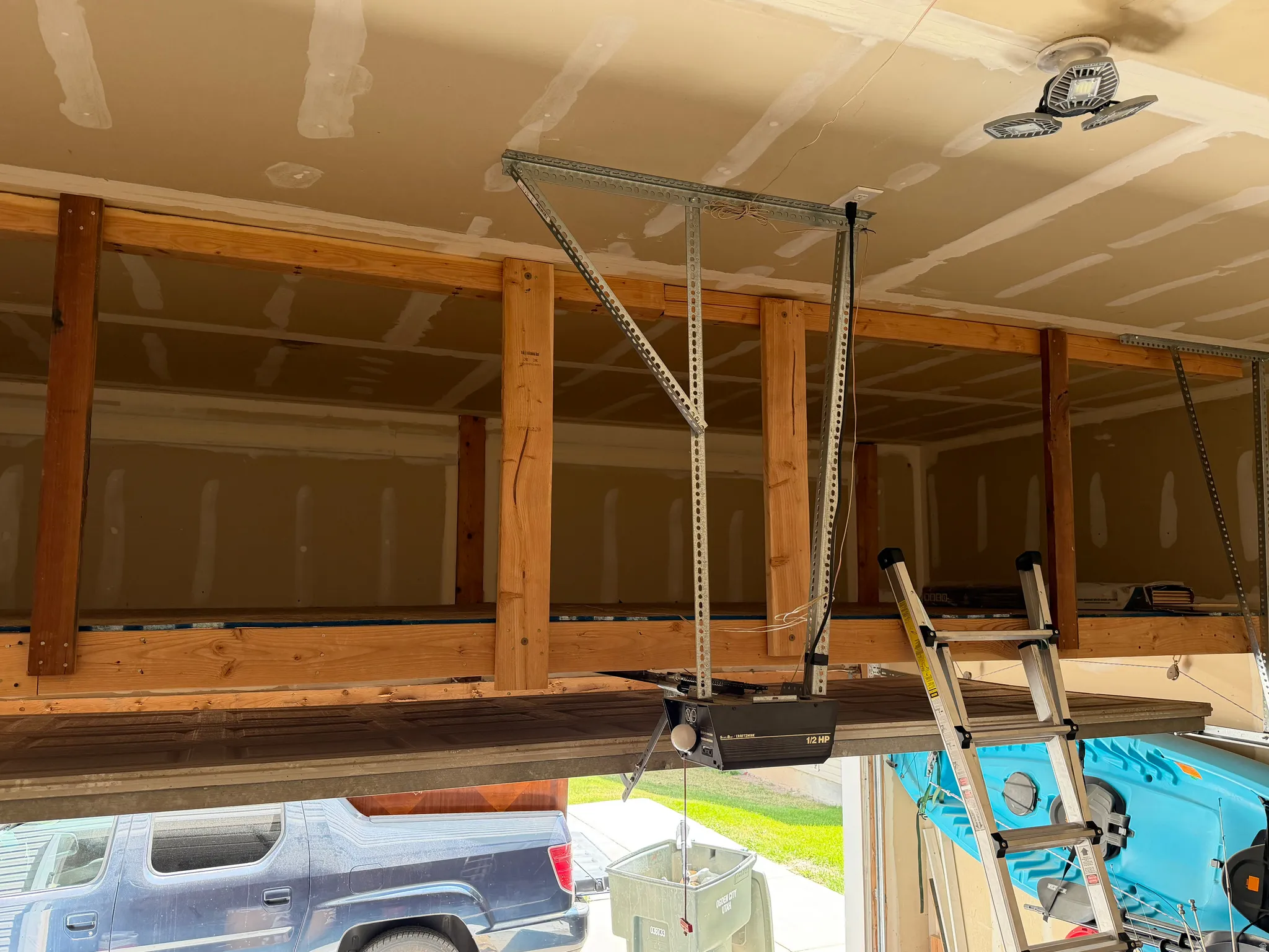Garage interior featuring built-in overhead storage, exposed wood framing, and a garage door opener