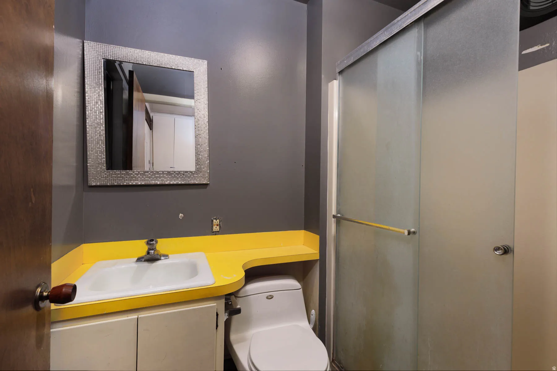 Bathroom featuring a vanity with a drop-in sink, vibrant yellow countertop, and white base cabinetry