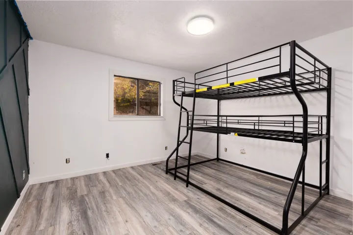 Room featuring wood-finish flooring, a contemporary ceiling light fixture, and a window with exterior views