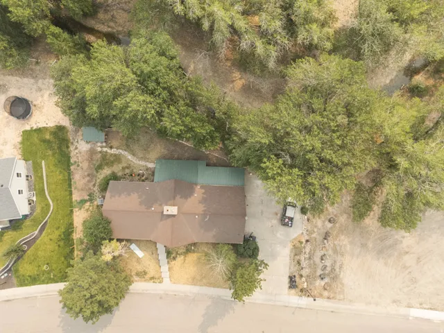 Aerial perspective showcasing a property surrounded by mature trees
