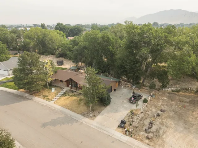 Ranch-style residence featuring a brown shingle roof, a front porch, and a stone walkway