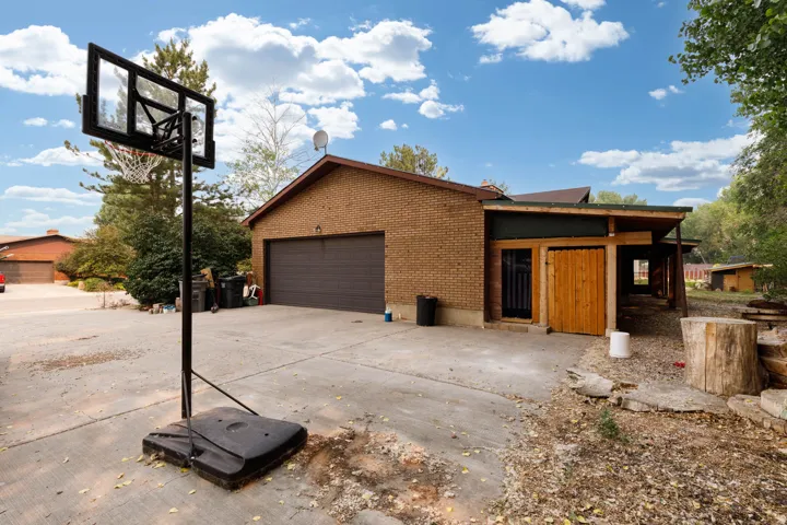 Brick exterior featuring an attached two-car garage with a brown door