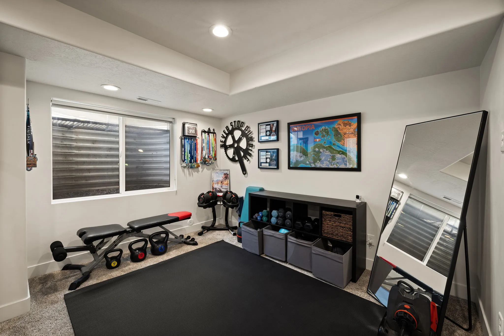 Spacious room featuring neutral carpeting, a large window with horizontal blinds, and recessed lighting