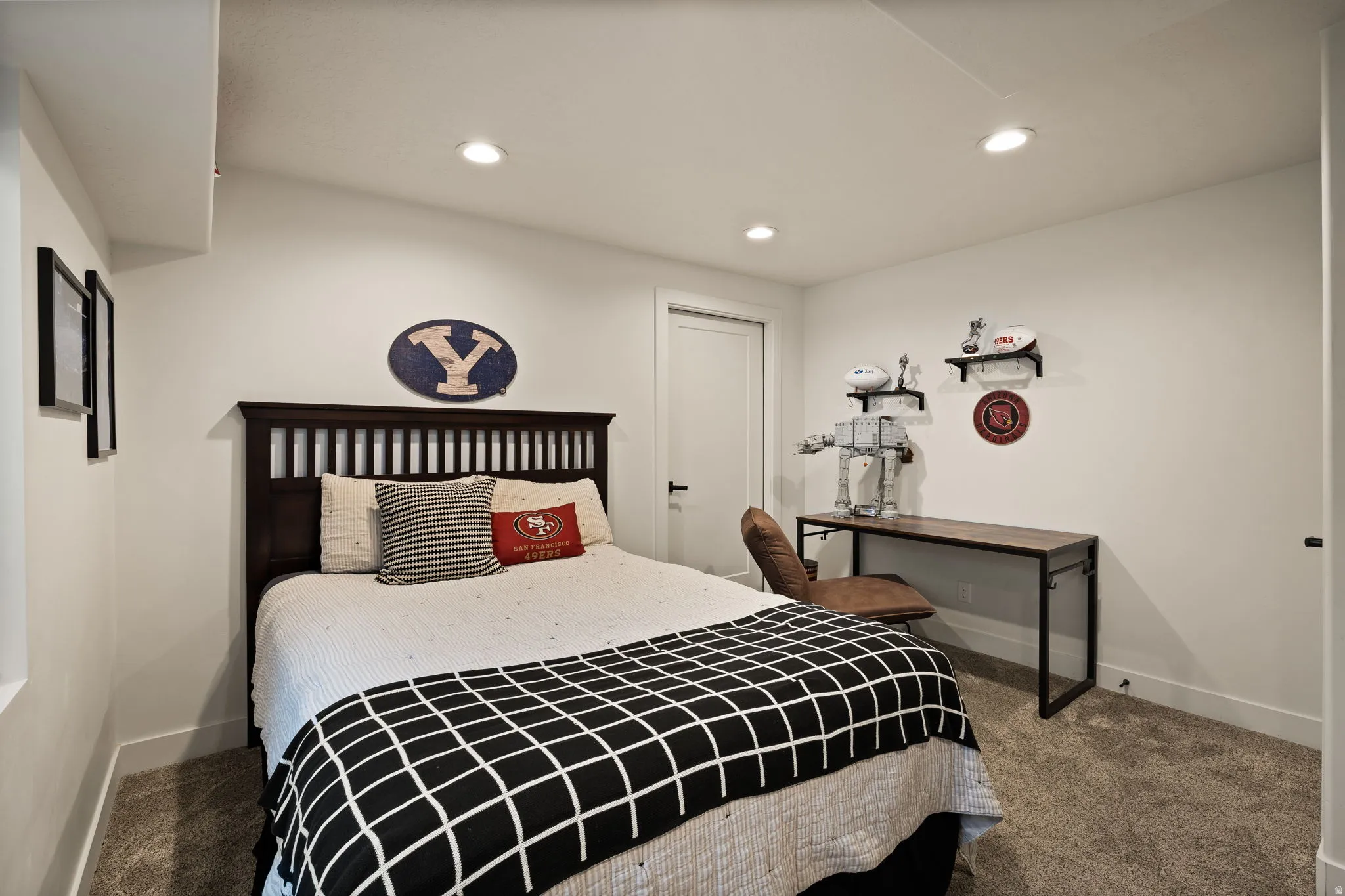 Bedroom featuring a dark wood slatted headboard, recessed ceiling lighting, and light-colored carpeting