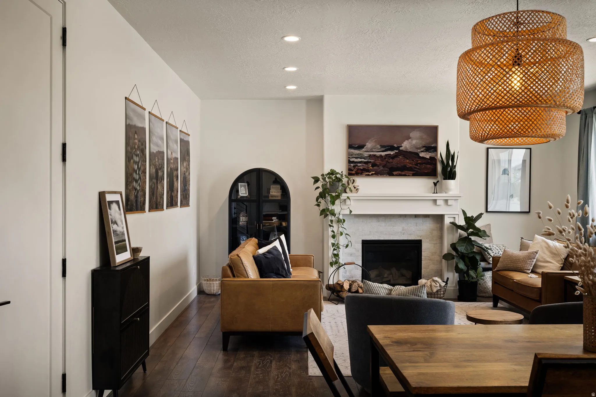 Spacious living area featuring dark wood-finish flooring, recessed lighting, and a white fireplace mantel with a light-colored surround