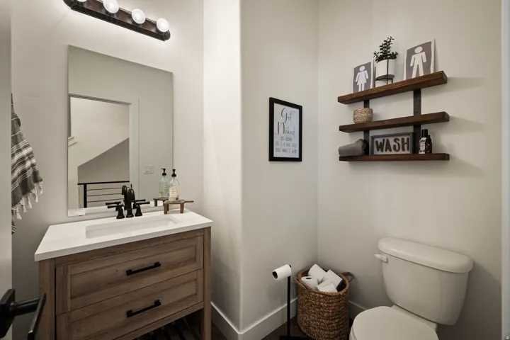 Modern vanity featuring wood-finish cabinetry, a white countertop, and a rectangular undermount sink with a matte black faucet